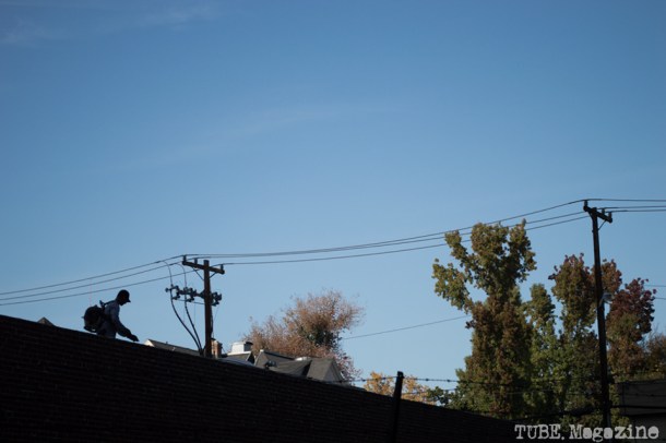 A worker blows leaves and debris off of the roof of a building on I Street. Photo M.Hershenow. 2014.
