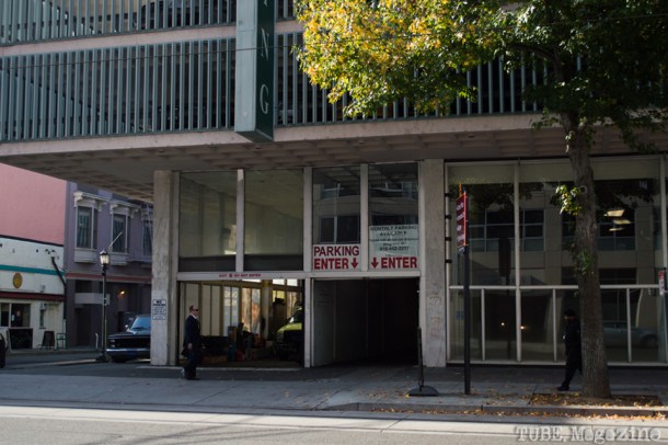 A businessman crosses in front of a parking garage on 8th Street. Photo M.Hershenow. 2014.