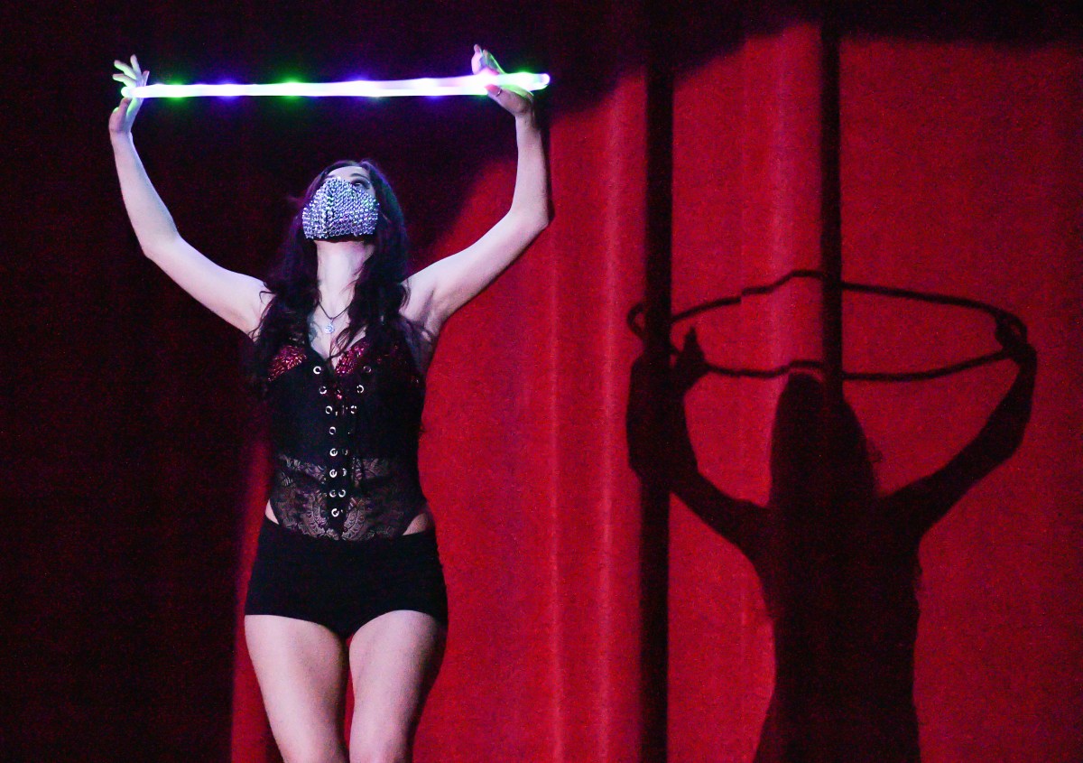 Ms. Tique holding hula hoop and wearing a mask