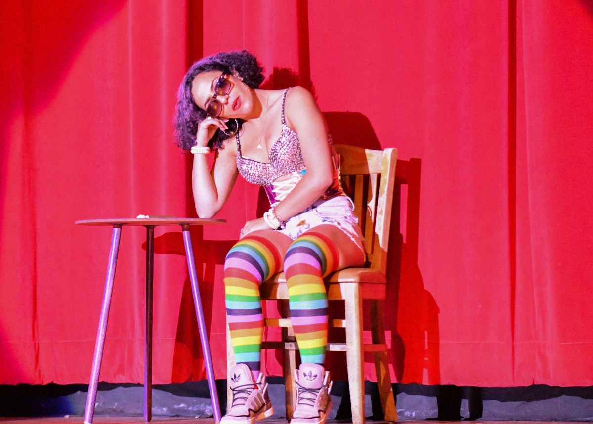 Dani Demize sitting in a chair and leaning on a table